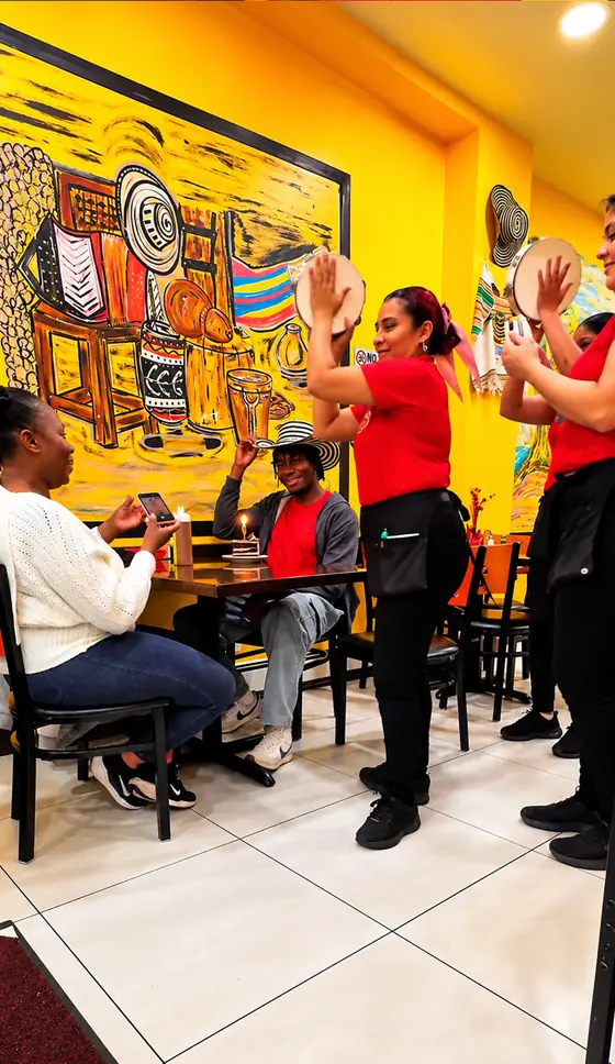 Staff singing happy birthday with tambourines for a customer at El Rinconcito Paisa 2